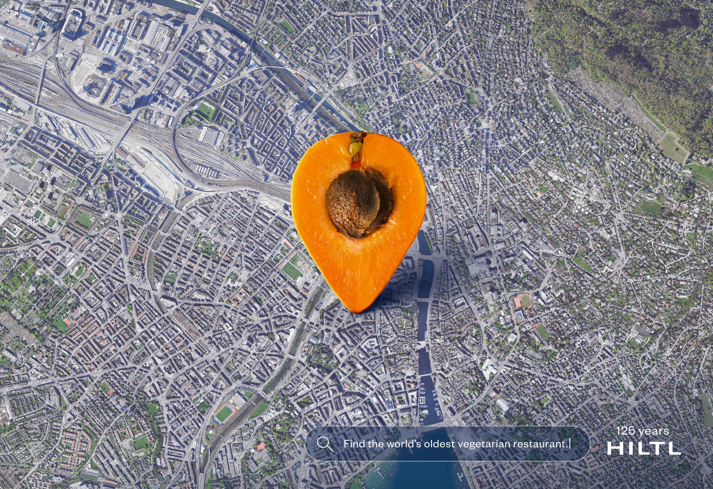 zum 125 Jahre Jubilaeum des Haus Hiltl: Google-Maps-Stecknadel, nach Suchtreffer in Form von einer aufgeschnittenen Aprikose im Zentrum Zurichs aus der Satellitenperspektive